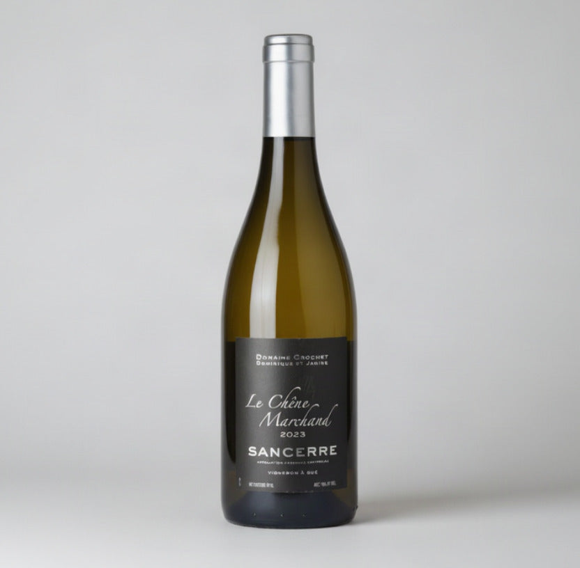 A bottle of Sancerre white wine from Domaine Crochet Le Château Marchand 2023, featuring a dark olive-green glass bottle, a black label with white text, and a silver foil capsule.