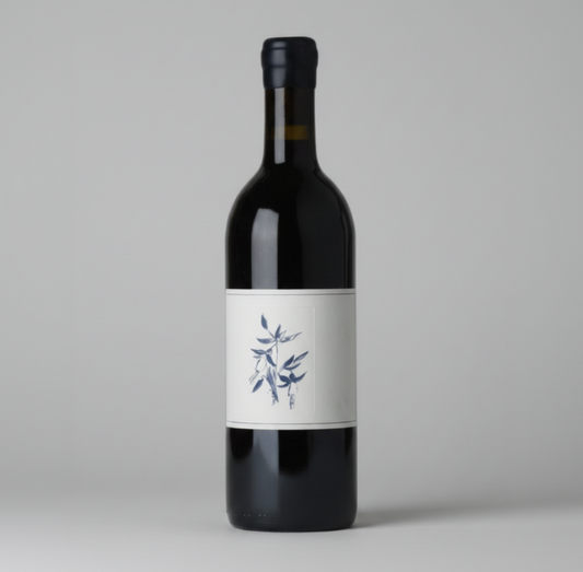 Red wine bottle with a white label featuring blue graphics on a black background